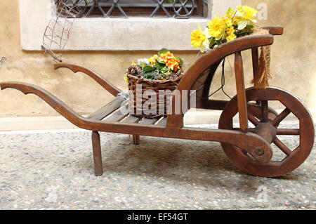 Vintage wooden cart with yellow flowers Stock Photo
