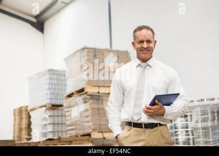 Manager standing with hand in the pocket holding tablet pc Stock Photo