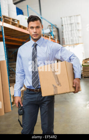 Warehouse manager holding cardboard box and scanner Stock Photo