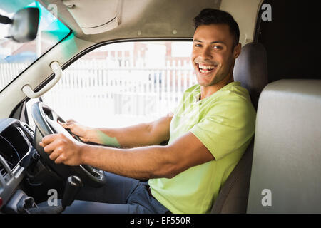 Delivery man driving his van while smiling at camera Stock Photo