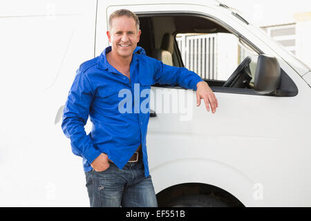 Smiling man leaning against his delivery van Stock Photo