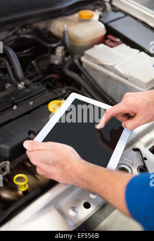 Mechanic using tablet to fix car Stock Photo