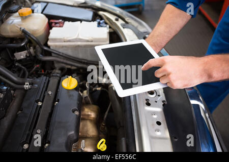 Mechanic using tablet to fix car Stock Photo
