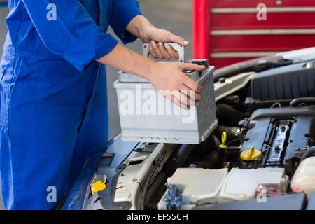 Mechanic examining under hood of car Stock Photo