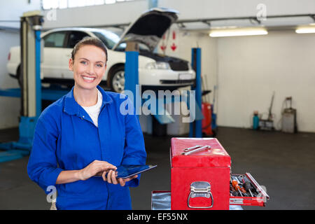 Mechanic smiling at the camera using tablet Stock Photo