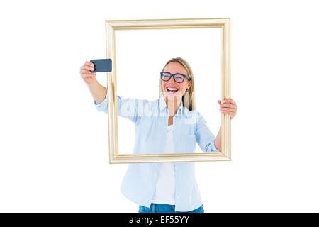 Blonde woman taking a selfie through a frame Stock Photo