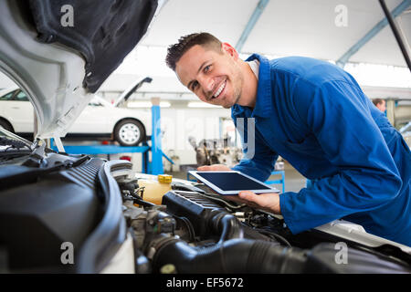 Mechanic using tablet on car Stock Photo