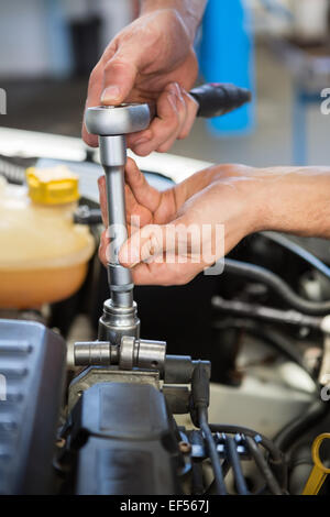 Mechanic working under the hood Stock Photo