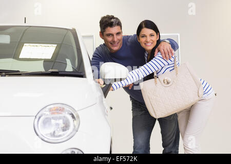 Smiling couple looking inside a car Stock Photo