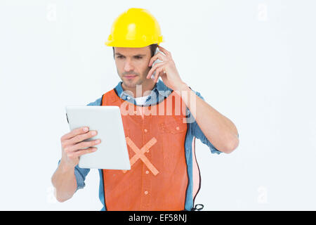 Carpenter using digital tablet and mobile phone Stock Photo