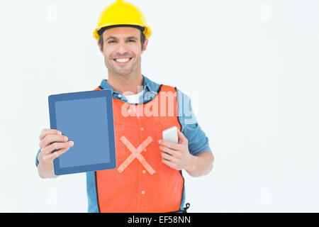 Carpenter holding digital tablet and mobile phone Stock Photo