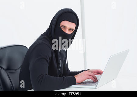 Hacker in balaclava looking at camera Stock Photo
