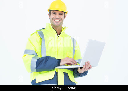 Male architect in reflective clothing using laptop Stock Photo