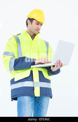 Architect in reflective clothing using laptop computer Stock Photo