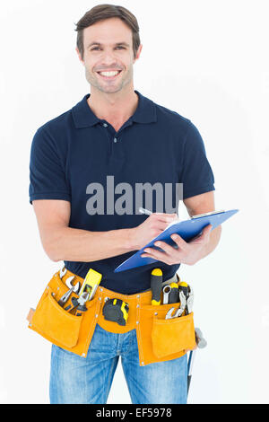 Handsome carpenter writing on clipboard Stock Photo