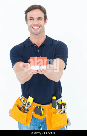Male architect holding model home over white background Stock Photo