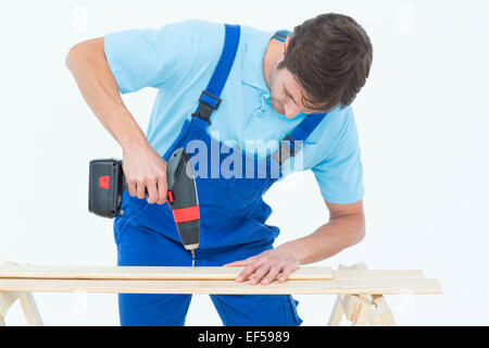 Carpenter using drill machine on wood Stock Photo