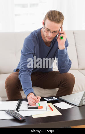 Concentrated man with glasses taking notes Stock Photo