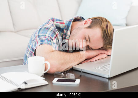 Tired man sleeping on his laptop Stock Photo