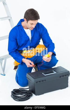 Electrician using multimeter over white background Stock Photo