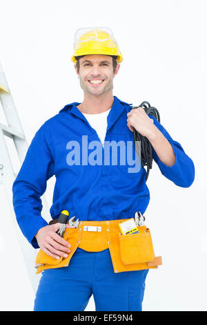 Happy electrician with wires against white background Stock Photo