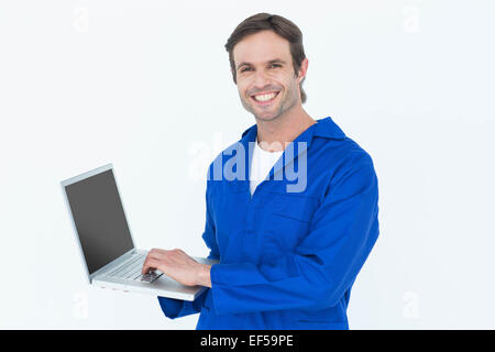 Handsome mechanic using laptop over white background Stock Photo