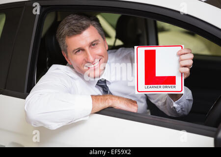Man holding a learner driver sign sitting behind the wheel Stock Photo