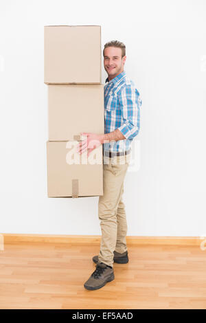 Smiling man carrying pile of cardboard moving boxes Stock Photo