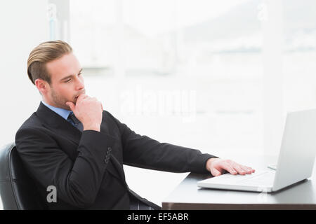 Focused businessman in suit using laptop Stock Photo