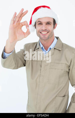 Delivery man in Santa hat gesturing OK sign Stock Photo