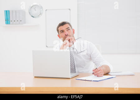 Worried businessman writing on is notepad Stock Photo