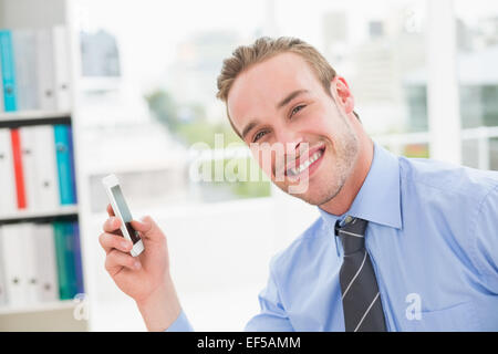 Smiling businessman using smartphone Stock Photo