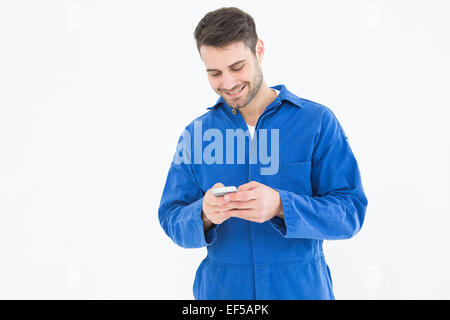 Male mechanic text messaging through mobile phone Stock Photo