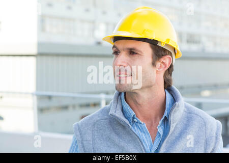 Thoughtful architect wearing yellow hard hat Stock Photo