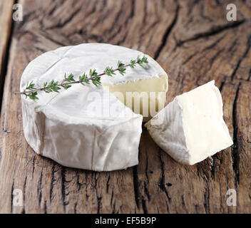 Camembert cheese on old wooden table. Stock Photo