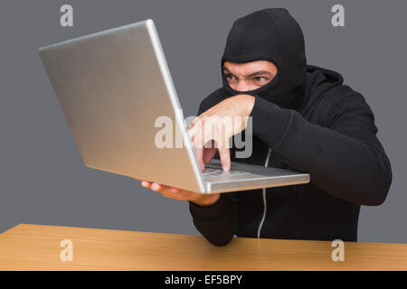 Hacker using laptop to steal identity Stock Photo