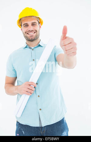 Male architect with blueprint gesturing thumbs up Stock Photo