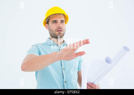 Architect with blueprint gesturing on white background Stock Photo