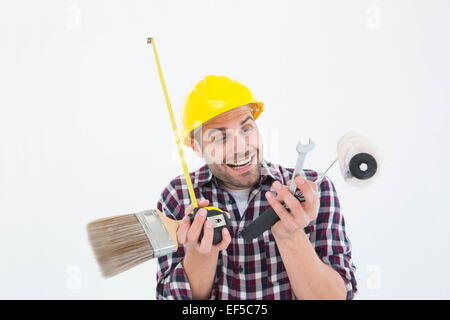 Happy repairman holding various tools Stock Photo