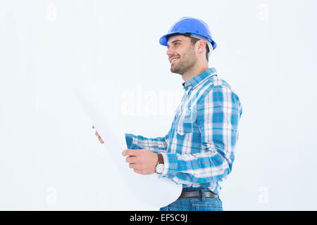 Smiling engineer looking away while holding blueprint Stock Photo