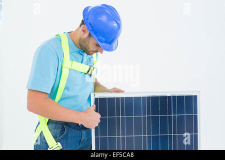 Construction worker examining solar panel Stock Photo
