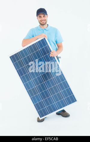 Smiling construction worker holding solar panel Stock Photo