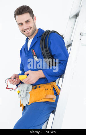 Happy construction worker leaning on ladder Stock Photo