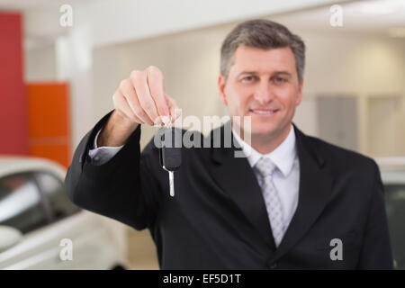Smiling salesman holding a customer car key Stock Photo - Alamy