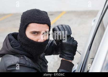 Thief breaking into a car Stock Photo