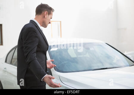 Businessman looking his car engine after breaking down Stock Photo
