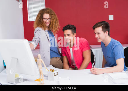 Smiling students working together on computer Stock Photo