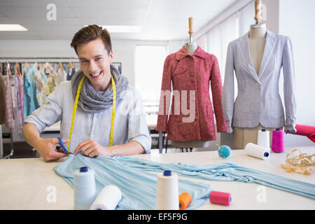 Student cutting fabric with pair of scissors Stock Photo