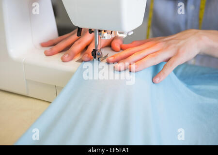 Close up of student using sewing machine Stock Photo
