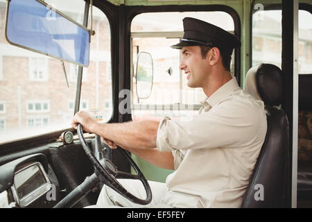Smiling driver driving the school bus Stock Photo